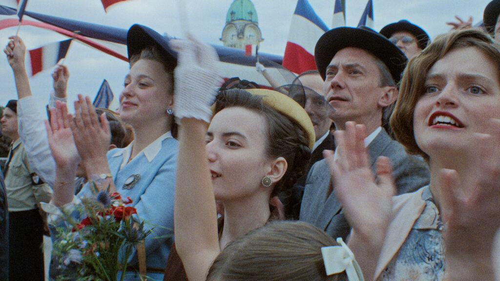 Swann Arlaud au milieu d'une foule agitant des drapeaux tricolores dans Notre salut, d'Emmanuel Marre